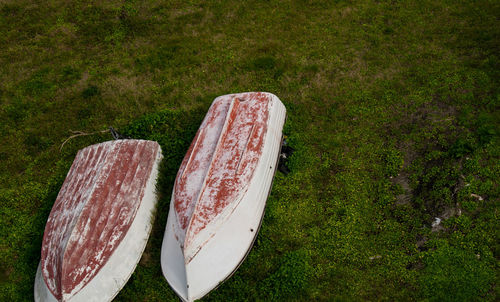 Two boats turned upside down on green field