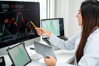 Midsection of woman using laptop at office