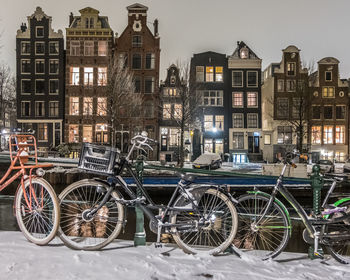 Bicycles parked on street by buildings in city