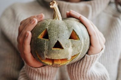 Midsection of woman holding pumpkin