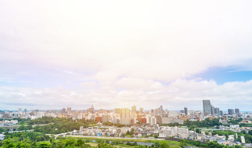 Aerial view of buildings in city against sky