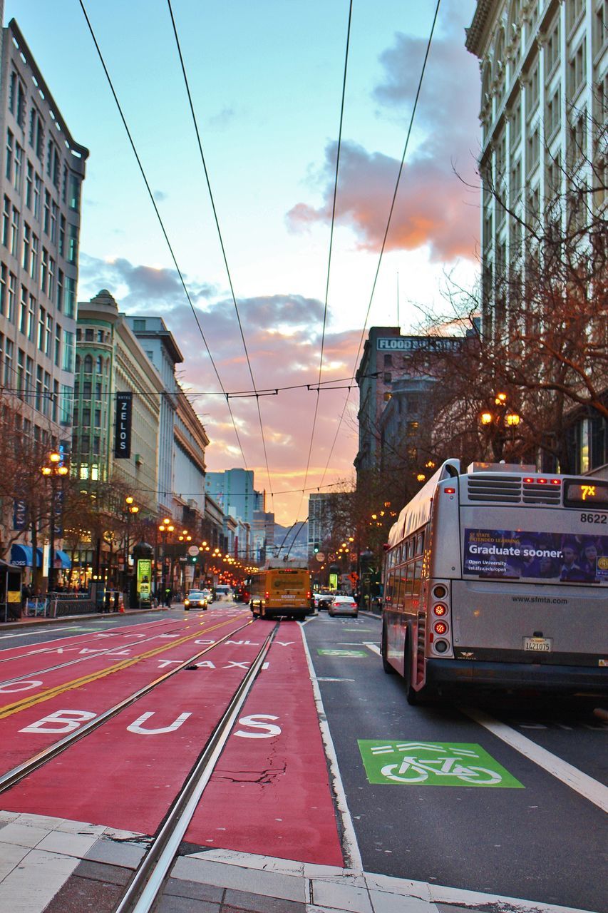 VEHICLES ON ROAD IN CITY AGAINST SKY