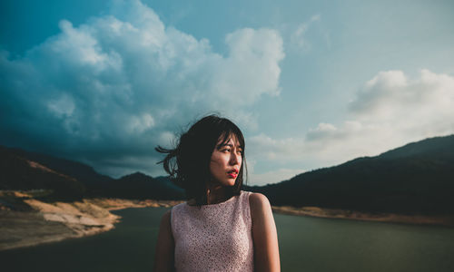 Portrait of woman standing against sky