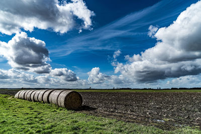 Hay bales on field against sky