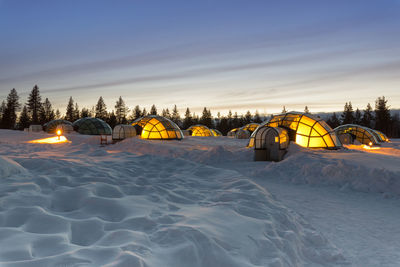 Snow covered landscape against sky at night