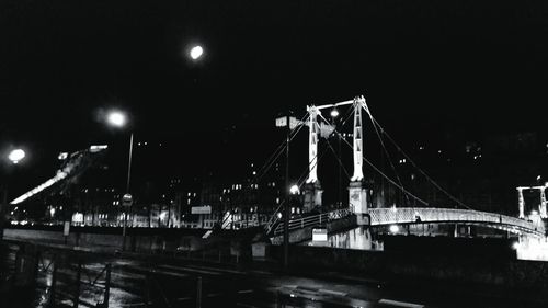 Suspension bridge over river at night