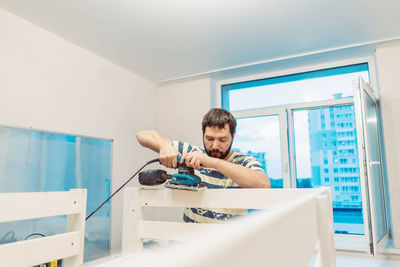 Side view of woman using mobile phone while standing in bathroom