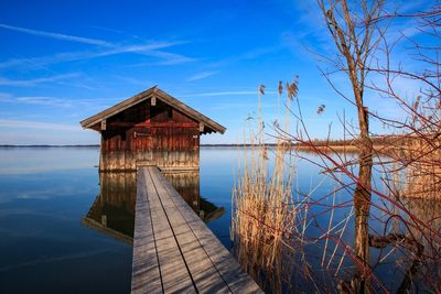 Gazebo by lake against sky