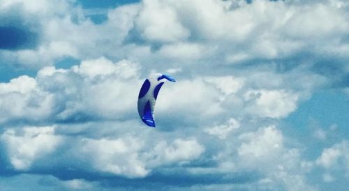 Low angle view of airplane flying against cloudy sky