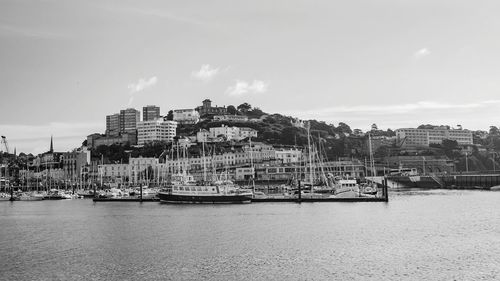 View of cityscape by sea against sky