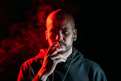 Portrait of man wearing mask against black background