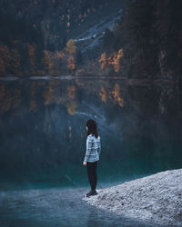 Full length of woman standing by lake