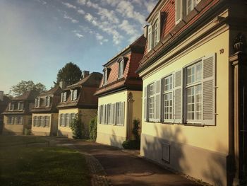 Houses by street in town against sky