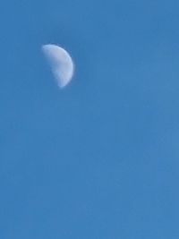 Low angle view of moon against blue sky