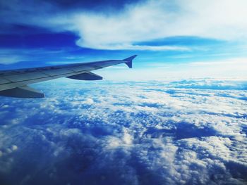 Cropped image of airplane flying over cloudscape