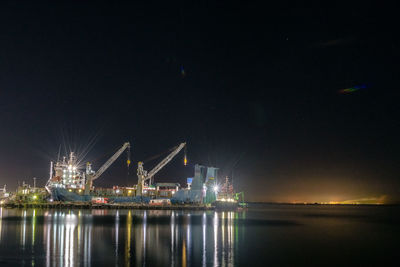 Illuminated commercial dock against sky at night