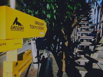 Close-up of yellow signboard against trees