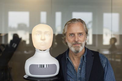 Portrait of senior man with robot voice assistant