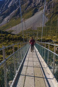 Rear view of men walking on footbridge