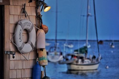 Life belt hanging on wall against river at dusk