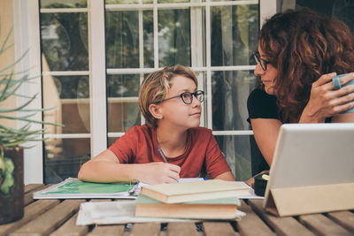 Woman using mobile phone while sitting on table
