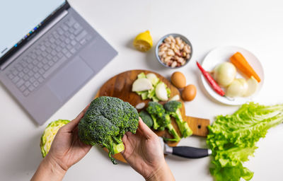 Cropped hand of woman holding food on table