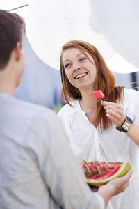 Woman eating watermelon at garden party, close-up