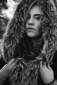 Close-up portrait of young woman wearing fur coat