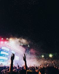 Crowd at music concert against sky at night