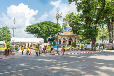 People on street against buildings in city