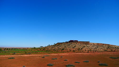 Scenic view of desert against clear blue sky