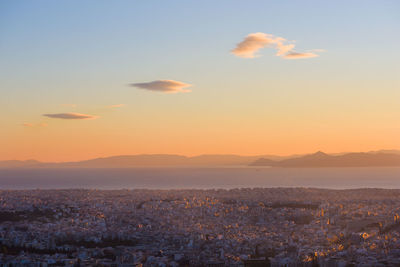Colorful sunset over athens, with acropolis, modern city and mediterranean sea, from lykabetus hill