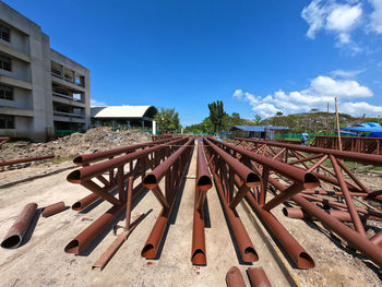 Railroad tracks by buildings against blue sky