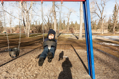 Full length of boy on swing during winter