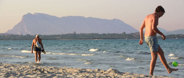 Woman standing on beach against sky