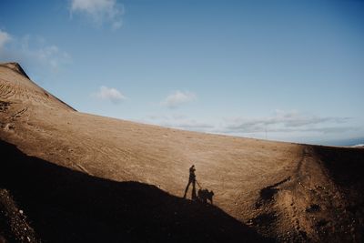 People walking on land against sky