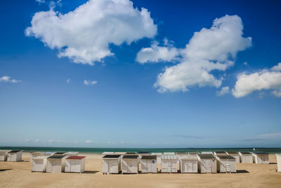Huts on beach against sky