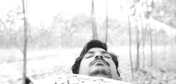 Portrait of young man against trees