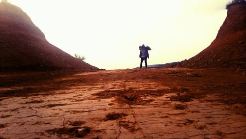 Man walking on desert against sky