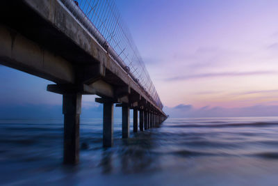 Low angle view of bridge over sea against sky