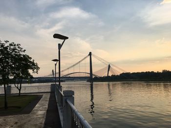 Bridge over river against cloudy sky