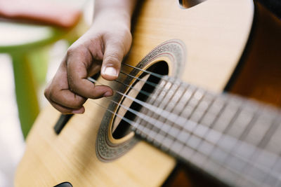 Cropped hand of man playing guitar