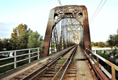 Railroad tracks by trees against sky