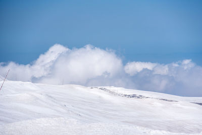 Scenic view of snow covered mountains against blue sky