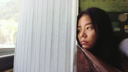 Portrait of woman looking through window