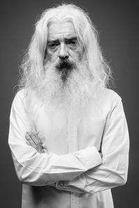 Portrait of man standing against black background