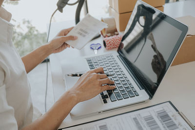 Midsection of man using laptop on table