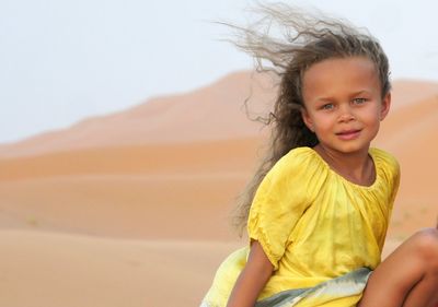 Portrait of smiling girl on sand at beach