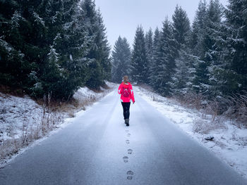 Rear view of woman walking on road