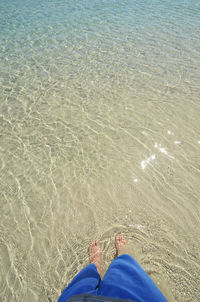 Low section of man standing on beach